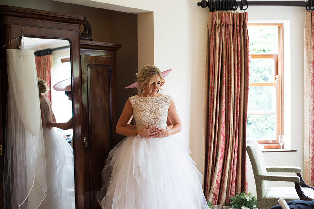 bride putting on dress at summer wedding at Tinakilly House