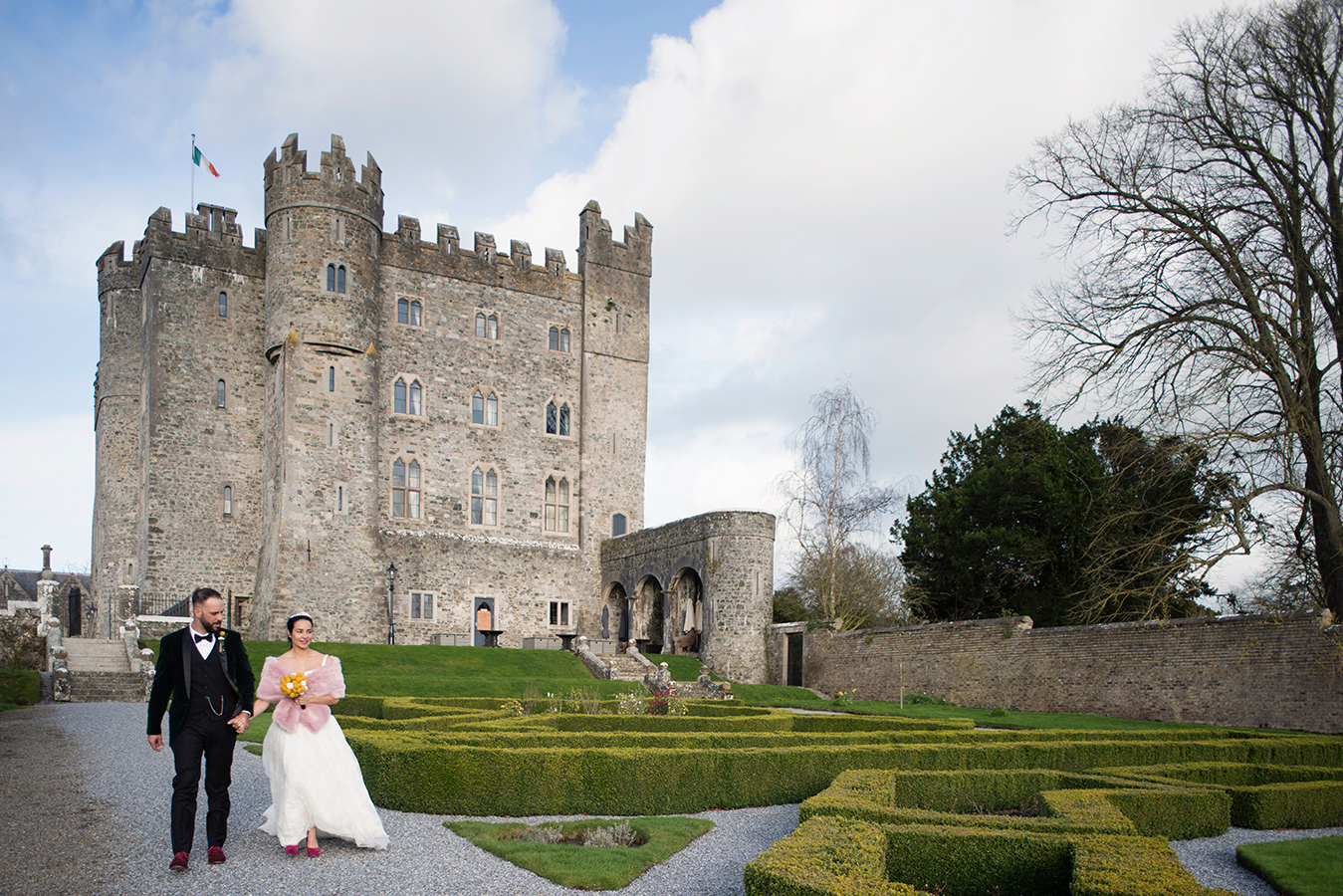 bride and groom walk in gardens of kilkea castle