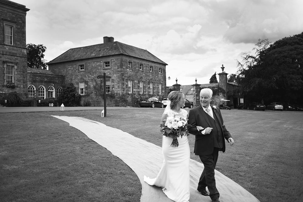 bride walkoing down aisle at outdoor wedding at Rathsallagh House