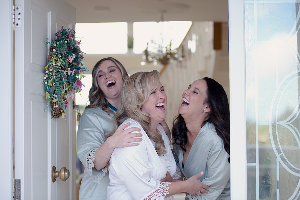 Bride and 2 bridesmaids laughing