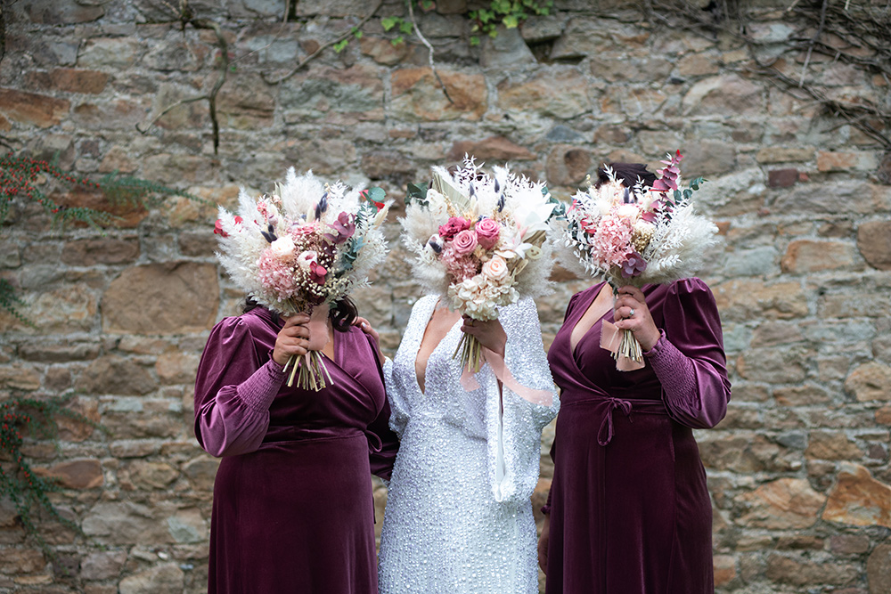 bride and two bridesmaids holding bouquets in front of them