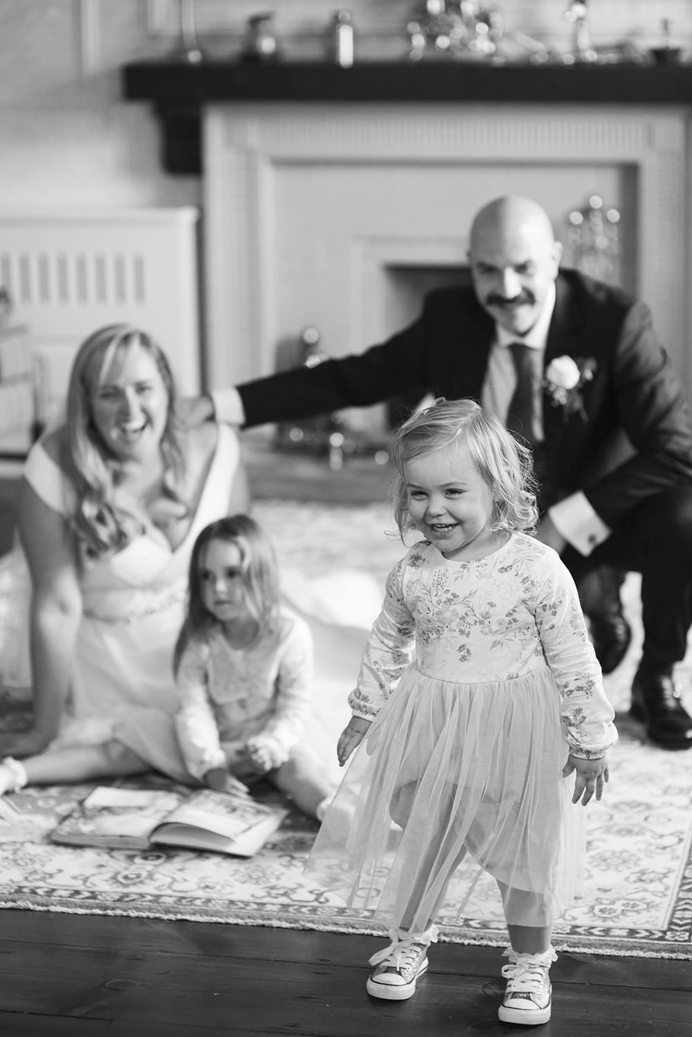 Black and white shot of bride and groom with their two daughters