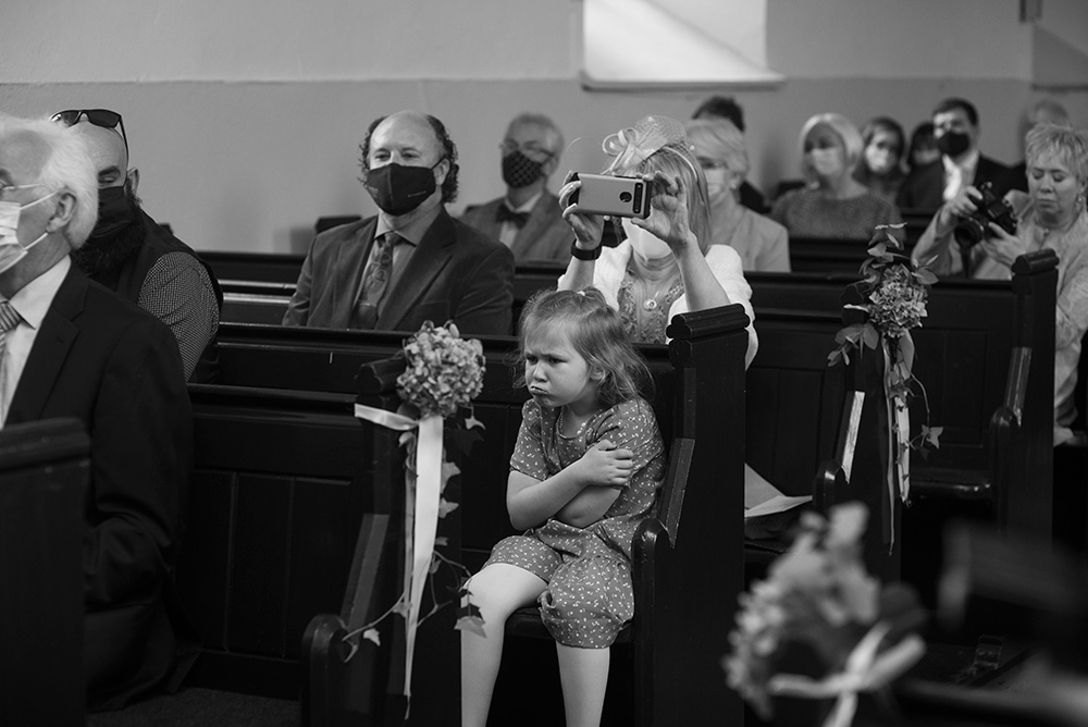 Young girl pouting during wedding ceremony