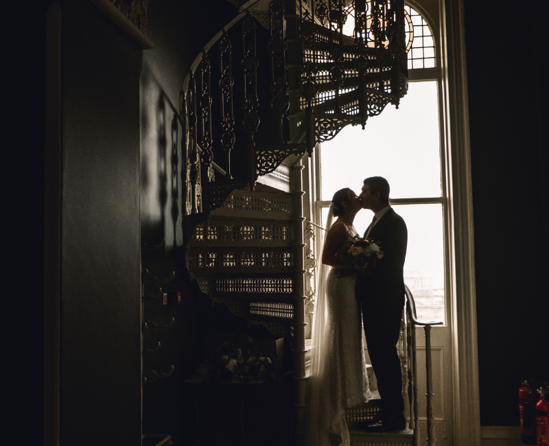 couple kissing in spiral staircase