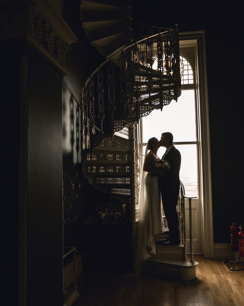 couple kissing in spiral staircase