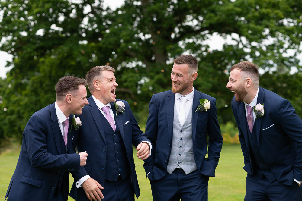 Groomsmen laughing in gardens at Rathsallagh House