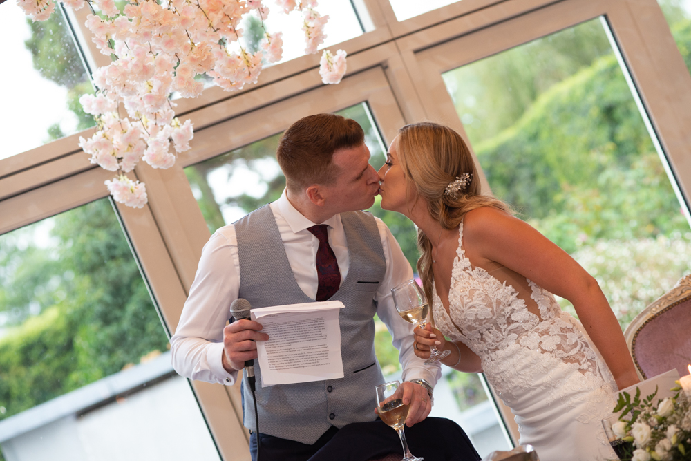 bride and groom kiss at speeches at Woodlands Hotel wedding
