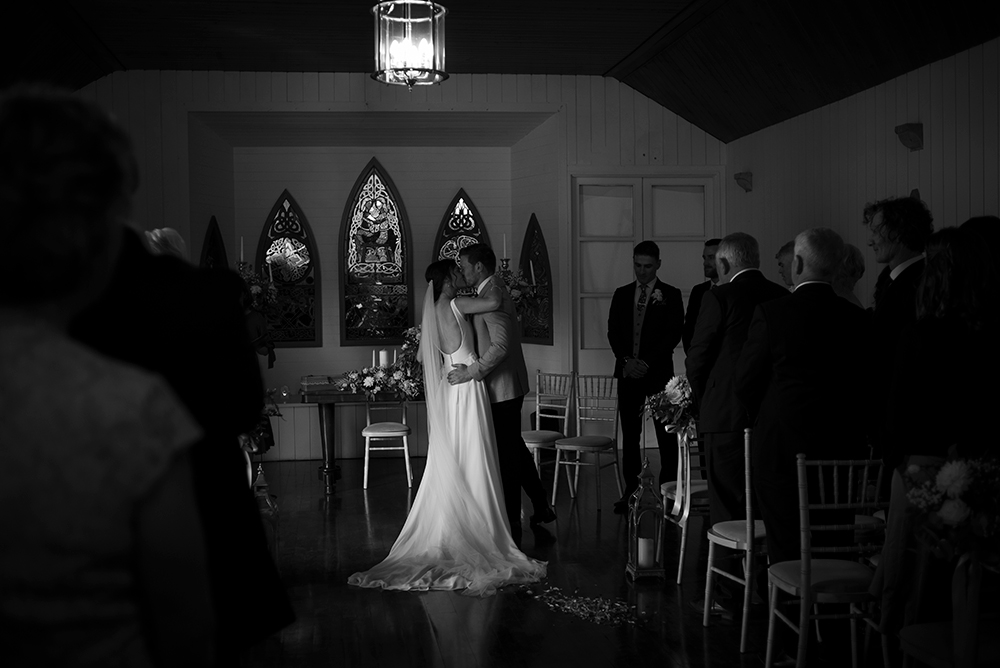black and white photo of first kiss during wedding ceremony at Clonabreany House