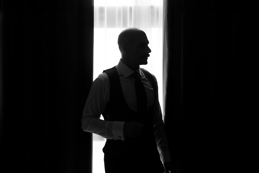 Black and white shot of groom backlit