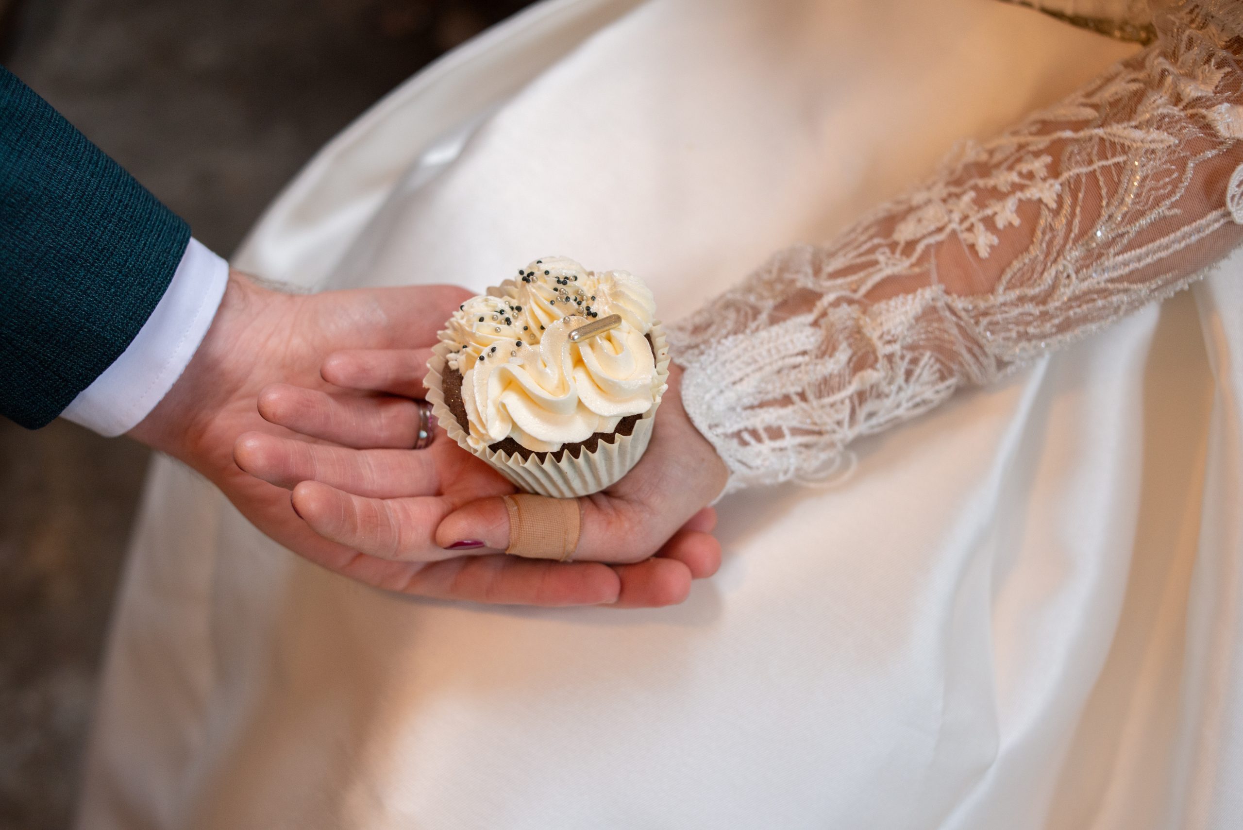 close up couple holding white cupcake