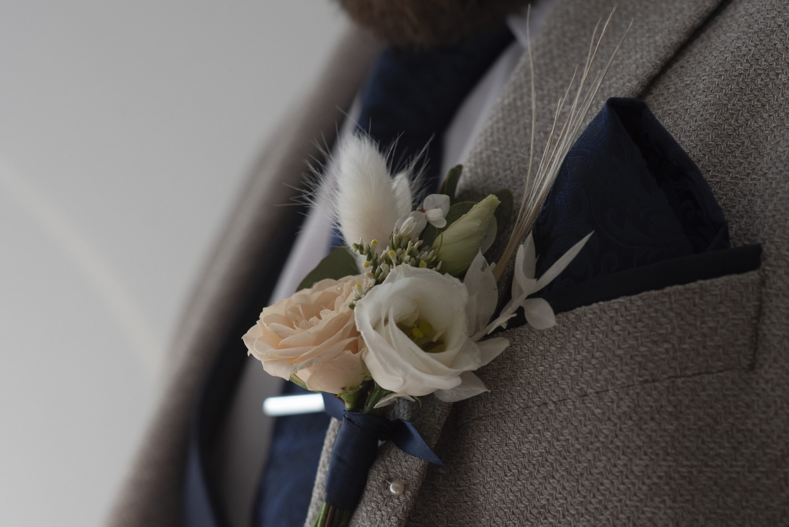 close up flowers on grooms suit
